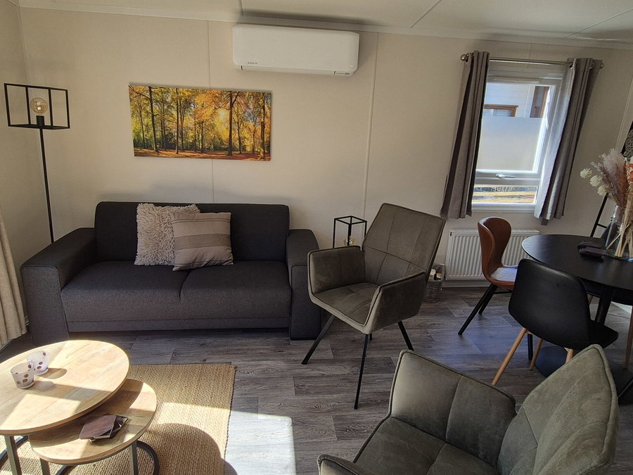 Sfeervolle woonkamer met moderne meubels en airco voor extra comfort. - Woonkamer